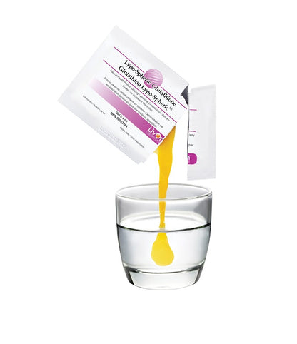 Yellow liquid being poured from a package into a glass of water on a white background
